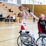 Ein Spieler von Varese setzt zum Wurf an und ein Spieler der Leopards de Guyenne verteidigt ihn mit erhobener Hand vor dem Gesicht.